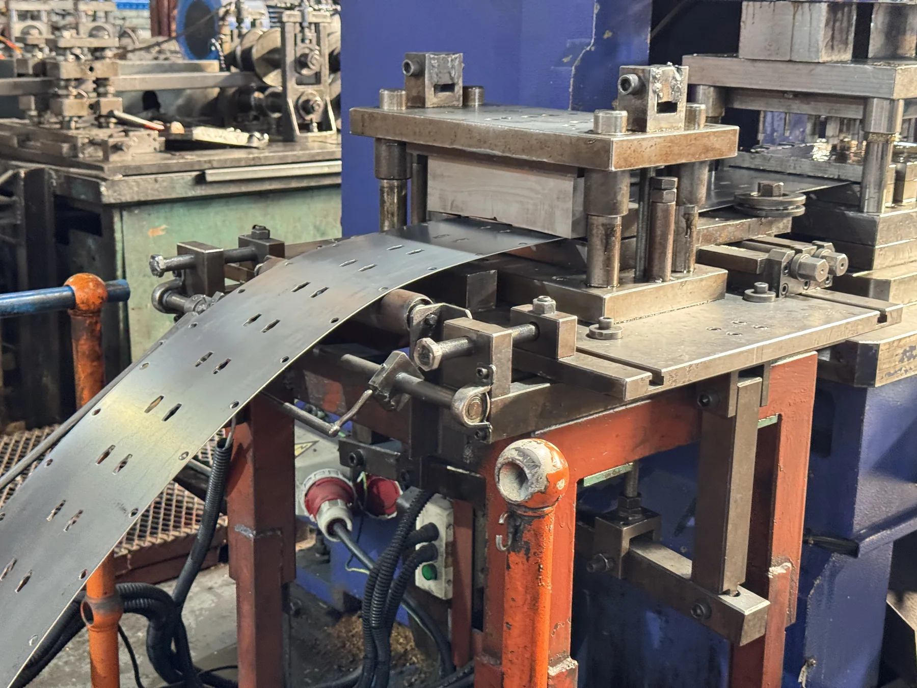 Progressive metal tooling and strip-feed equipment in a VAS project workshop